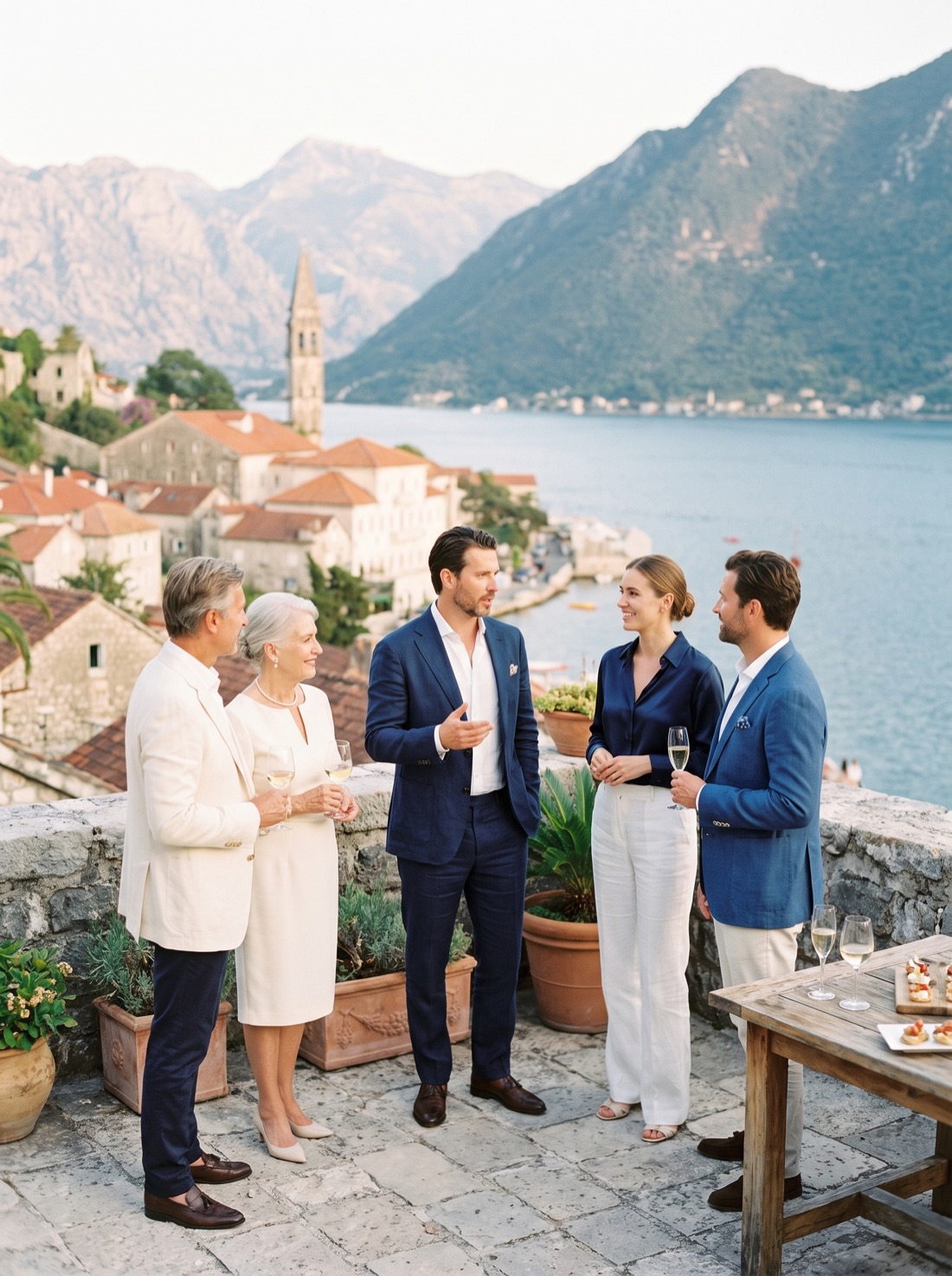 Guests in conversation on a terrace above the Bay of Kotor